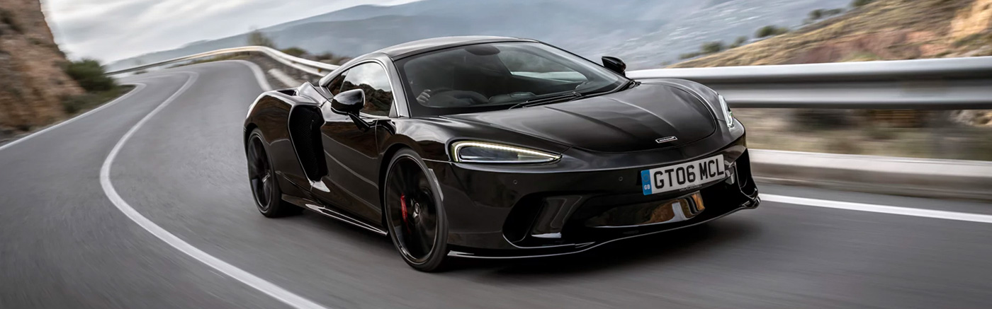 3/4 view of the McLaren GT driving down winding road