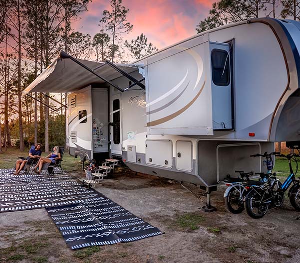 People sitting outside their RV