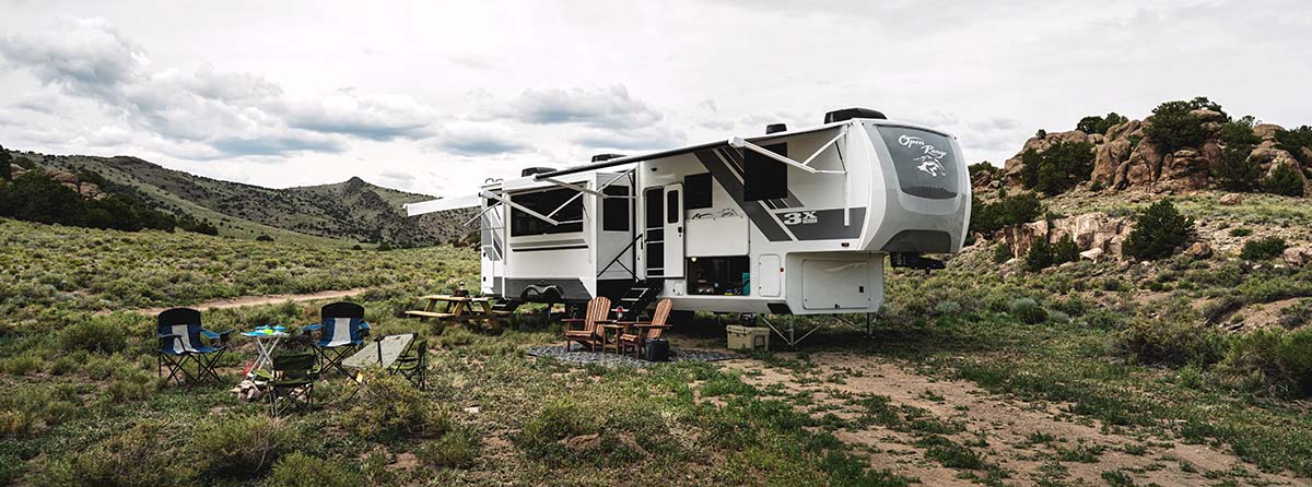 An RV parked in front of mountains