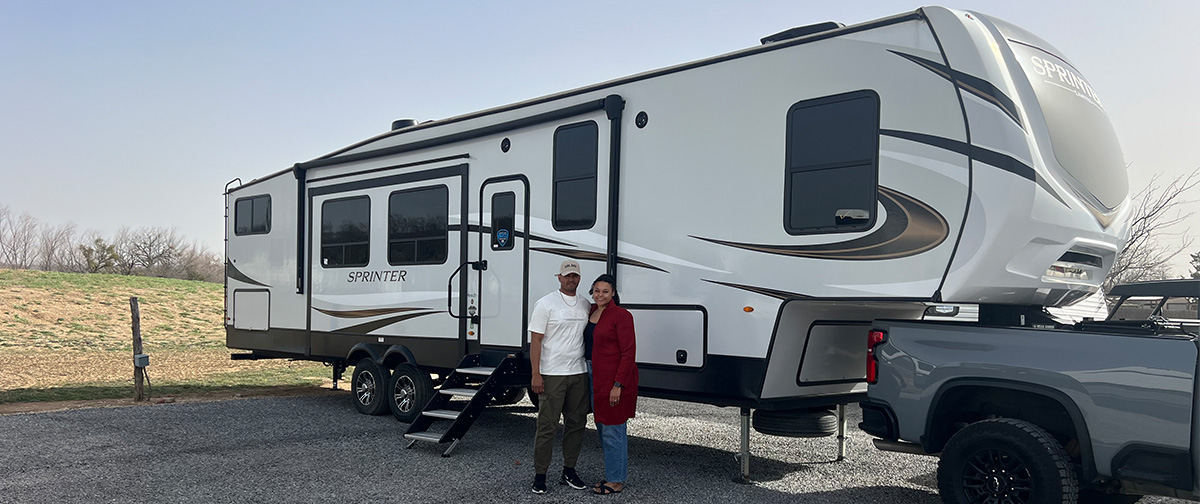 Smiling couple in front of an RV