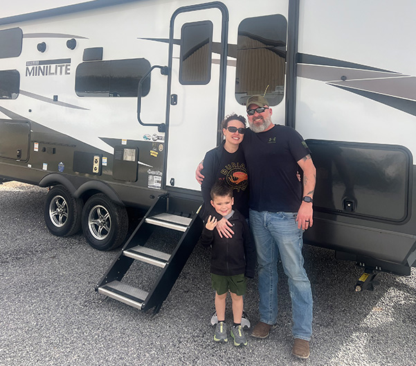 Smiling family in front of an RV