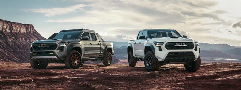 Two Toyota Tacoma's parked on a rocky terrain