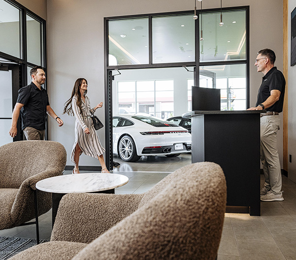 Dealership employee smiling greeting happy customer.