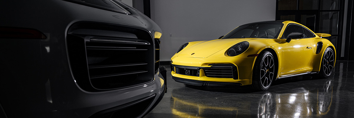 Porsche vehicles parked on showroom floor.